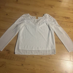 Vit blus med spetsdetaljer - Säljer en vit blus med långa ärmar och vackra spetsdetaljer över axlar och bröst.                                Storlek s och den är fin i skicket 💕