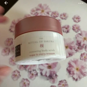 Rituals body scrub - Rituals The Ritual of Sakura renewing body scrub med socker och körsbärsblom. Kommer i en vit burk med rosa lock och har en fräsch, blommig doft. Perfekt för att exfoliera huden och ge en silkeslen känsla.