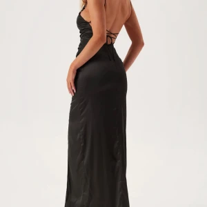 Svart långklänning med öppen rygg - Supersnygg svart långklänning i satinliknande material med smala axelband, öppen rygg och snörning. Klänningen har en slits framtill som ger en extra touch.                                               Säljer denna nu då den är lite för lång och jag är 162 cm och har längre ingen användning av den! Passar bra till lärrarmiddagar eller andra tillställningar🤗 endast använd en gång🙌🏼 Pris kan diskuteras 😍