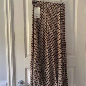 Mönstrad långkjol Richard Allan x H&M - Vackert figursydd kjol med fint fall. Slutar mitt på vaden på mig som är 166-168cm. Passar även någon i XS skulle jag säga. Säljs inte längre på H&M. Är från h&ms Collab med Richard Allan.