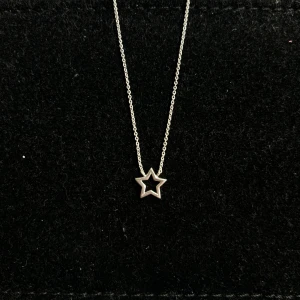 Guldfynd stjärnhalsband 925 silver - Snyggt halsband i äkta silver med en öppen stjärnformad berlock. Kedjan är tunn och smidig, perfekt för dig som gillar stilrena smycken med en liten twist. Passar till alla tillfällen och är lätt att matcha med andra accessoarer. 42-46cm