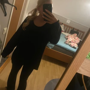 Svart stickad tröja - En svart stickad tröja i storlek L med rund halsringning och långa ärmar. Tröjan har en oversized och loose passform, perfekt för lager-på-lager och chill vibes. Enkel och stilren design utan mönster eller detaljer.