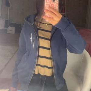 Mörkblå Sail racing hoodie - Säljer en mörk blå Sail racing hoodie för den då aldrig kommer till användning har använt den max 5 gånger.