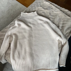 Vit stickad tröja  -  Vit stickad polotröja från Stories i storlek S. Tröjan har en hög ribbad krage.