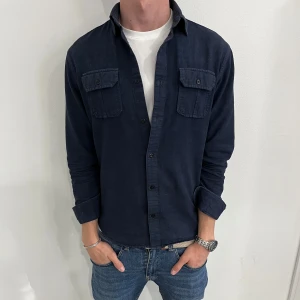 Mörkblå overshirt med fickor  - Stilren mörkblå overshirt med två bröstfickor, från Jack and Jones.  Säljs inte längre i butik!                              Skick 8/10✅.                               Storlek small.                                         Hör av dig vid några funderingar!