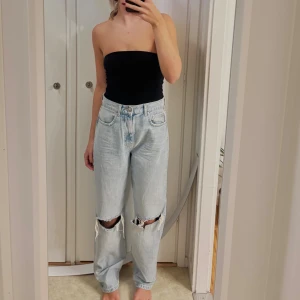 Ljusblå baggy jeans med hål på knäna - Säljer ett par ljusblå jeans med baggy passform och stora slitna hål över båda knäna. Jeansen har hög midja, oxh köptes på Gina .strl 36 men för stora för mig