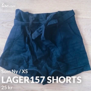 Svarta högmidjade shorts Lager157 XS - Snygga svarta shorts från Lager157 i högmidjad modell med bred midja och knytband. De har en loose passform och är tillverkade i mjukt bomullstyg. Perfekta för varma dagar och har praktiska fickor framtill.