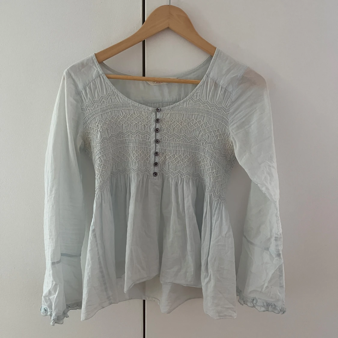 Ljusblå blus med smock och knappar