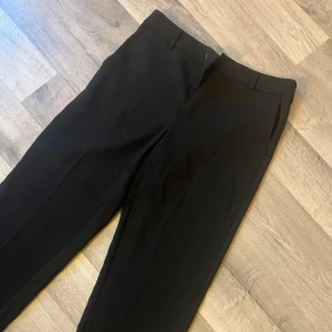 Svarta kostymbyxor Gina Tricot  - Klassiska svarta kostymbyxor från Gina Tricot i storlek 36. Säljer de för jag själv tycker de är för korta på mig som är 174. Skulle säga att de sitter som en blandning av bootcut och raka kostymbyxor men väldigt fina och enkla💘