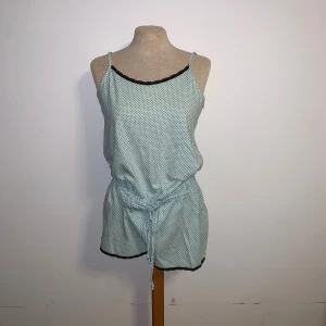 Prickiga ljusblå romper från Bodyzone - Jätte söt pajama/sommar romper i ljusblå med svarta prickar från Bodyzone, KappAhl. De har snörning i midjan och svart spetsdetalj längs kanterna. Materialet är mjukt och känns skönt.