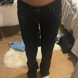 Mörkblå jeans från ONLY, stl 27/34 - Snygga mörkblå jeans från ONLY med kontrastsömmar. Modellen har normal/tight passform och raka ben, perfekt till sneakers eller boots. Jeansen är tillverkade i slitstarkt denim och går ej att få tag på.(stora för mig)