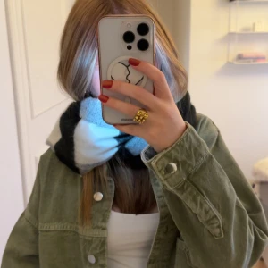 Rutig svartvit halsduk i mjukt material - Snygg och stor halsduk med rutigt mönster i svart, grått och vitt. Perfekt att vira flera varv runt halsen för en mysig look. Materialet känns mjukt och värmande, passar perfekt till kalla dagar och ger en cool vibe till din outfit.