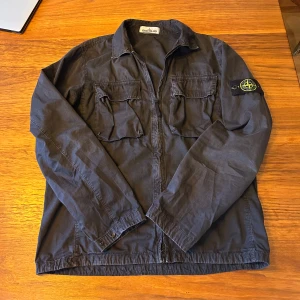 Stone Island overshirt - Snygg overshirt från Stone Island med klassisk patch på ärmen. Jackan är i super skick inga defekter. Pris kan diskuteras, skriv om ni undrar över något! 🫡