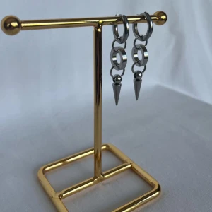 Silvriga örhängen med kedjor och spikes - Coola silvriga örhängen med ringar och kedjor som avslutas med spetsiga spikes. De har en edgy vibe och passar perfekt om du gillar att sticka ut med din stil. Materialet är metall och designen är modern med en industriell känsla.