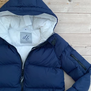 Mörkblå pufferjacka från db - Tja säljer en asfet vinterjacka! Den är i storlek m men passar också s. Jackan har lite fläckar under luvan kom priv om bilder och frågor