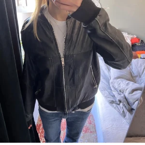 Svart vintage skinn bomberjacka  - Säljer en svart bomberjacka i skinn. Jackan har silverfärgade dragkedjor, ribbade muddar och klassisk bomberkrage. Har vanligtvis xs/ s och sitter lite oversized på mig🩷