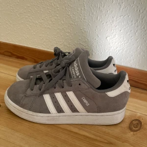 Grå Adidas Campus sneakers - Säljer mina gråa adidas campus 2 unisex skor. Älskar dessa men tyvärr så är de för små, då dessa är små i storleken så jag fick gå upp en storlek. Därav så har jag endast använt dessa några gånger och de har inget slitage, utan är bara lite smutsiga. Skulle rekommendera dessa till nån mellan 36-37🩷💕