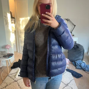 Mörkblå Polo Ralph Lauren dunjacka  - Snygg mörkblå jacka perfekt för hösten! Jättefin mörk färg och polo Ralph lauren märket sitter på bröstet. Har två fickor på utsidan som går att stänga med dragkedja och är bekväm! Orginalpriset var 2500 och har bara använt den två gånger! Skulle säga att jackan sitter som s eller xs beroende på person, jag är 1,64.