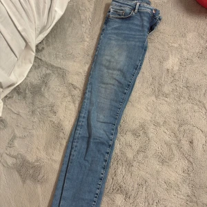 Blå Peachy Low 540 skinny jeans  - Säljer ett par ljusblå skinny jeans från Bikbok i storlek S/31. Jeansen har låg midja, klassiska fem fickor och dragkedja. Snygg tvätt med lätt slitning och smal passform som sitter tajt hela vägen ner. En liten reva som man ser på sista bilden annars väldigt fina och endast använda några gånger.