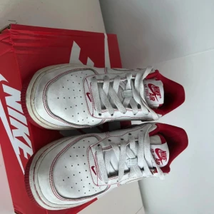 Nike Air Force 1 vit/röd 38.5 - Nike Air Force 1 white university red, använda men i bra skick, slitage finns o syns på bilderna