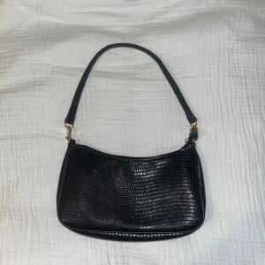 Svart liten väska - Svart liten väska med gulddetaljer