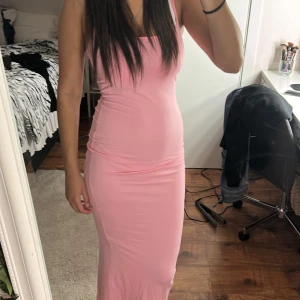 Ljusrosa långklänning från SHEIN - Säljer en ljusrosa långklänning från SHEIN i storlek XS. Klänningen har smala axelband och en figurnära passform. Tillverkad i mjuk och stretchig polyesterblandning som sitter snyggt på kroppen. Perfekt för dig som gillar enkel och stilren look.