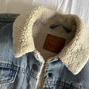 Levi's jeansjacka med teddyfoder M - Äkta Levis jacka med foder. Väl använd men fortfarande i gott skick utan defekter. Perfekt till kalla höst dagar och tillräckligt varm att använda på vintern. 