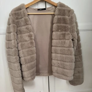 Biege päls jacka Gina tricot - päls jacka från Gina Tricot köpt för ca 3 år sedan men har knappt kommit till användning. Jackan är storlek M. Skulle inte säga att den är super varm utan mer än höst jacka inte vinter, eller bara för att göra outfit finare. Jackar har en hake i mitten så den går att stänga på mitten som man ser på sista bilden. Skriv för mer info eller bilder 