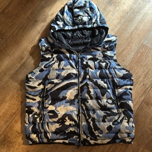 Moncler väst unik - Unik moncler väst i färg watercamo såklart en äkta vara och släpper det till ett väldigt bra pris då den kostar runt 10000 ny. I ett väldigt fina skick utan hål eller fläckar