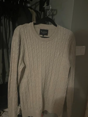 Beige kabelstickad tröja från Bondelid - Säljer en beige kabelstickad tröja från Bondelid i storlek M. Tröjan har rund halsringning, ribbade muddar och lång ärm. Perfekt för lager-på-lager och passar till både jeans och chinos.