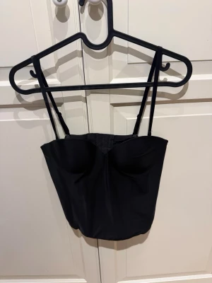 Svart korsettopp från H&M, 80A - Säljer en svart korsettopp från H&M i storlek 80A. Toppen har justerbara och avtagbara smala axelband. 