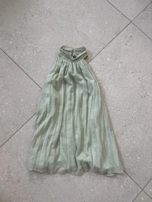 Ljusgrön festtopp - Säljer denna ljusgröna fest/sommartoppen med lite skimrigt tyg och fina knappar i ryggen! 