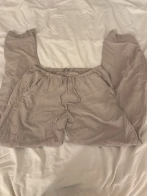 Beige linnebyxor - Säljer ett par beige linnebyxor från lager157 i storlek XXS. Byxorna har resår i midjan med snörning och två sidofickor. De är raka i modellen och har en avslappnad passform, perfekta för chill dagar.