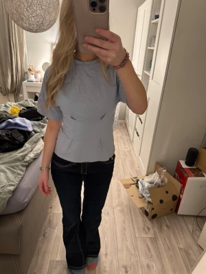 Ljusblå kortärmad t-shirt - Säljer en ljusblå t-shirt med korta ärmar och figurnära passform. T-shirten har en enkel design med diskreta sömdetaljer framtill och rund halsringning. Perfekt för dig som gillar stilrena och fräscha plagg.