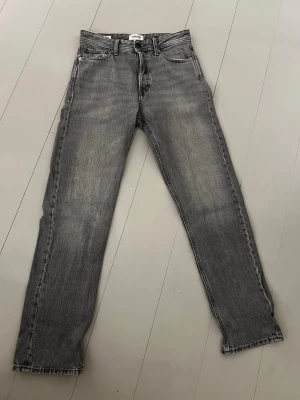 Grå relaxed jeans Jack & Jones 28/32 - Säljer ett par grå jeans från Jack & Jones i modellen Relaxed/Chris. De har en relaxed passform med raka ben och klassisk femficksdesign. Jeansen är tillverkade i bomull och har en snygg tvättad look som ger en avslappnad vibe.