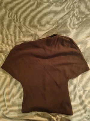 Brun stickad tröja från Gina Tricot - Mysig brun stickad tröja från Gina Tricot i storlek S. Tröjan har en enkel, rak passform och är tillverkad i ett mjukt material som passar perfekt för kyligare dagar. Stilren design utan mönster eller detaljer.