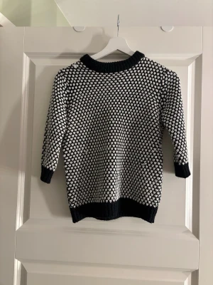 Svartvit stickad tröja från Zara Knit - Säljer en svartvit stickad tröja i storlek S. Tröjan har ett coolt mönster med vita prickar över hela och ribbade muddar vid hals, ärmslut och nederkant. Perfekt för dig som gillar en unik och mysig stil.❣️❣️