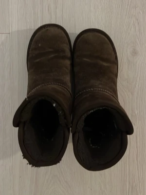 Ugg liknande - Säljer ett par bruna ugg liknande vinterskor från Pieces. Skorna har platt sula och rund tå, perfekta för kalla dagar. Storlek 37 ❣️helt okej skick