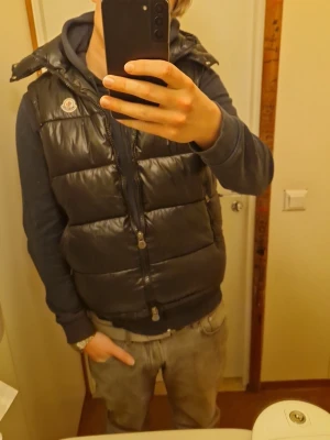 Svart dunväst från Moncler - Säljer en svart, glansig dunväst från Moncler med klassisk logga på bröstet. Äkta moncler köp du den snabbt så blire billigare 