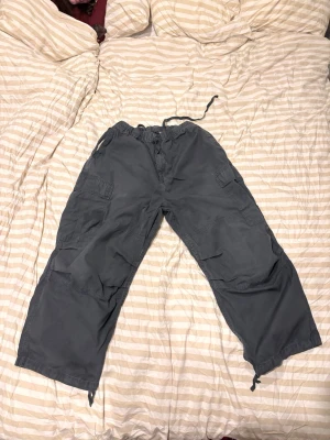 Gråa cargobyxor från Carhartt - Säljer ett par cargobyxor från Carhartt Work In Progress i färgen ”Vulcan Rinsed”. Tillverkade i bomull med detaljer i polyester på fickorna. Perfekta för en chill och streetwear-inspirerad look. Har använt dem vid ca 10 tillfällen - praktiskt taget nya. Köpta på zalando.