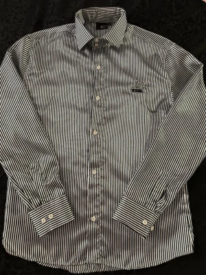 Randig skjorta från Just Cavalli XL - Snygg skjorta från Just Cavalli i svartvitt randigt mönster. Klassisk krage, långa ärmar och knappar framtill. Tillverkad i en skön mix av bomull och polyester. Perfekt för dig som vill ha en stilren och trendig look.