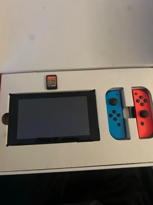 Nintendo Switch med Joy-Con och Minecraft - Nintendo Switch spelkonsol med två Joy-Con kontroller i blått och rött.  Skärmen är i toppskick !! Spelet Minecraft ingår! Tagit hand om detta väl funkar utmärkt!