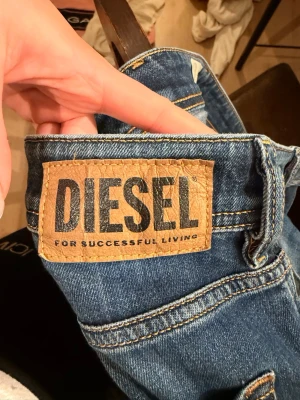 Diesel Sleenker-X slim jeans blå 30 - Säljer ett par snygga blåa Diesel Sleenker-X jeans i storlek 30. Modellen är slim-skinny med klassisk femficksdesign och gul kontrastsöm. Jeansen har en mörk tvätt med lätt slitning och är tillverkade i mjukt bomullsjeansmaterial.