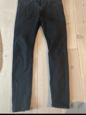 Svarta Levi's jeans straight fit - Säljer ett par svarta Levi's 511 jeans med straight fit och klassisk femficksdesign. Jeansen har normal passform och är tillverkade i mjukt bomullsjeansmaterial. Perfekta för dig som gillar en enkel och stilren look.