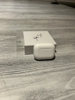 Apple AirPods Pro trådlösa hörlurar - Säljer ett par vita Apple AirPods Pro med laddningsetui. Snygg och kompakt design i blank plast, perfekt för dig som vill ha grymt ljud och smidig anslutning till din iPhone. Levereras i originalförpackning.