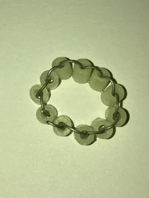 Handgjord ring med pärlor och metalltråd - Unik ring gjord av självlysande ljusgröna, runda plastpärlor som är sammanlänkade med tunn metalltråd. Ringen har en enkel och kreativ design som sticker ut och passar dig som gillar DIY-stil och personliga accessoarer. Frakt 22-100kr. Kontakta mig om du har frågor eller vill köpa.