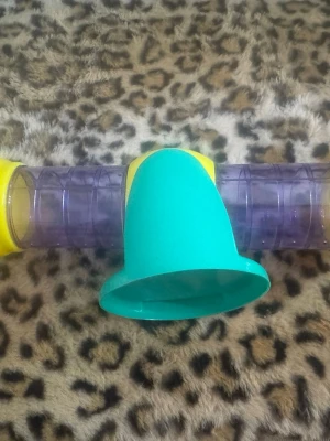 Färgglad plasttunnel för smådjur - Säljer en plasttunnel i gult, grönt och lila som passar perfekt till smådjur som hamster eller mus. Tunneln har genomskinliga sektioner och en grön öppning i mitten. Enkel att montera i bur eller lekplats.