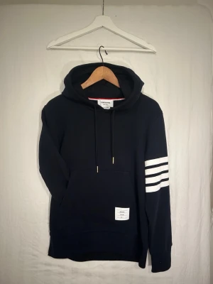 Thom browne hoodie - En riktigt fet thom browne hoodie i storlek 2 vilket motsvarar S på ett ungefär. Tröjan är i mycket bra skick utan defekter. Skriv vid minsta intresse!😊