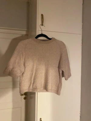Stickad tröja &other stories - Superfin beige stickad trekvarts tröja från &other strories. Använd en del och har dessvärre krympt lite i tvätten, inte super mycket men tyget känns lite sträft. Är stolek S men passar som en liten S eller XS. Hör av er vid frågor!💕