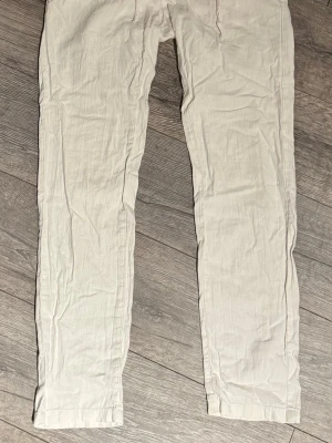 Vita linnebyxor från Lindbergh - Snygga vita linnebyxor från Lindbergh med avslappnad passform och elastisk midja. Perfekta för varma dagar och ger en clean och fräsch look. Tillverkade i luftigt linne som känns skönt mot huden.